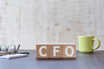 There is wood cube with the word CFO. It is an acronym for Chief Financial Officer an eye-catching image.