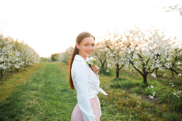 Naklejka na ściany i meble Portrait of happy woman. Blooming garden in spring.