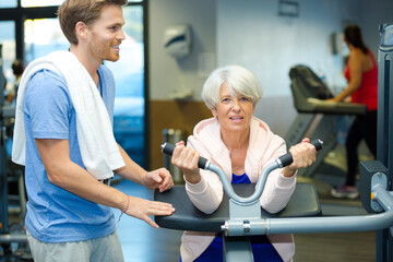senior woman doing sport exercises with coach or personal trainer