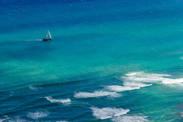 View of the city of Honolulu from above at the top of Diamond Head Crater, in Oahu, Hawaii. Sail boats and buildings.