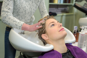 young beautiful girl is having hairwash in a salon closeup