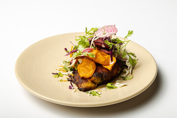 Close Up, Fried fish with spices and vegetables, served on a plate with a white background.