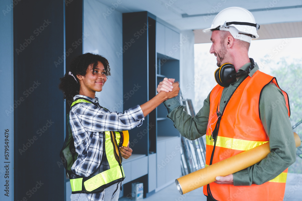 Wall mural Group of multi ethnic engineer construction site worker meeting at workplace, Architects working together at construction site to remodeling home or building. hands on