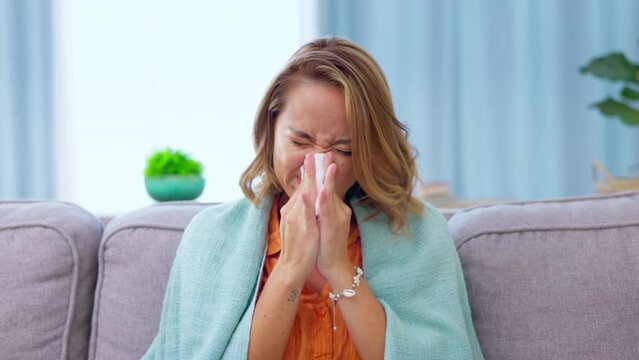 Sick, blowing nose and woman with tissue in home with cold, flu or illness. Covid, toilet paper and female sneezing on sofa in living room with allergy, virus or disease, fever or sinusitis in house.
