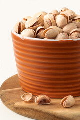 Pistachios in a bowl isolated on white background.