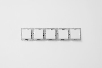 Modern plastic switches on white wall. Installing lighting