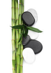 Spa stones and bamboo on white background, top view