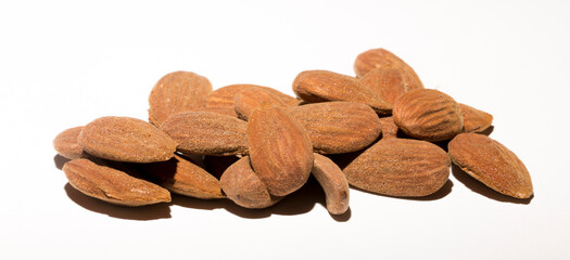 Shelled almonds (Prunus dulcis). A lot of peeled almonds on a white field.