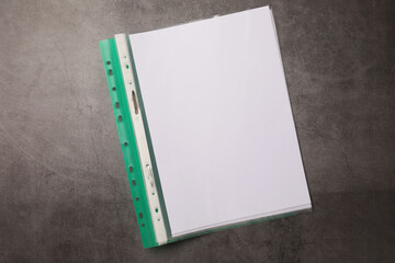 File folder with punched pockets on grey table, top view. Space for text