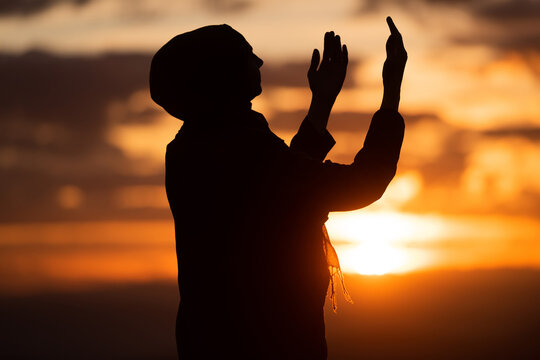 Muslim woman prayer having worship and praying with hands open doing dua to Allah at sunset 