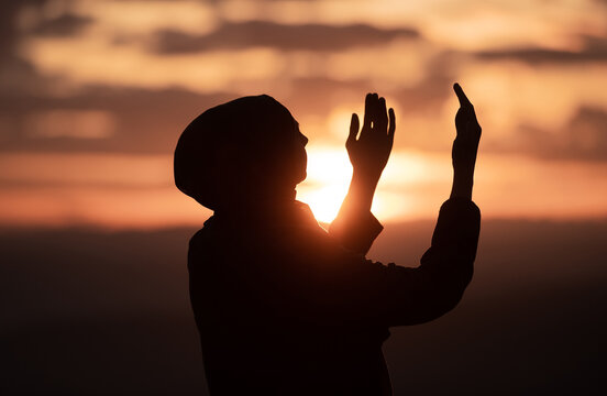Muslim woman prayer having worship and praying with hands open doing dua to Allah at sunset 
