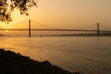 Fototapeta na wymiar 25th of April Bridge - Sunset over Tejo river in Lisbon