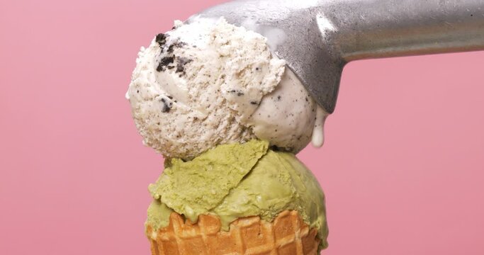 Front view of an ice cream cone with green tea ice cream and cookies and cream on top.