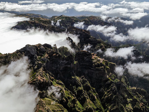 Stone peaks of mountains among the clouds, top view from a drone.