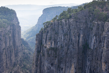 Fototapeta premium Massive mountain cliffs extending into the fog in the distance
