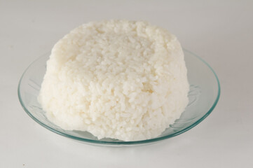white rice is served on a small plate isolated on a white background