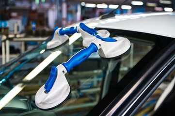 Suction pads for car windshield installing in workshop - 579570296