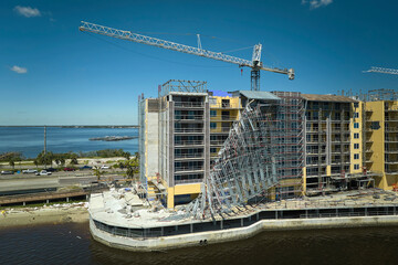 Aerial view of ruined by hurricane Ian construction scaffolding on high apartment building site in...