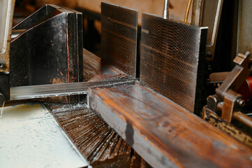 Cutting metal beam with band saw in plant workshop