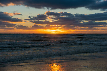 Obraz na płótnie Canvas Ocean sunset landscape with soft evening sea water waves crushing on sandy beach