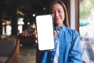 Mockup image of a beautiful young woman showing a mobile phone with blank white screen