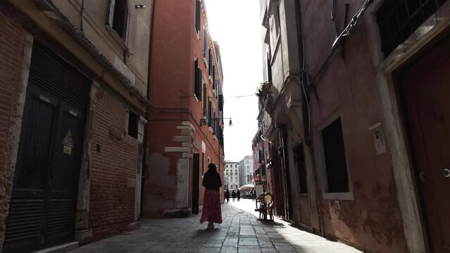 Back View Of A Woman Walking Through Old Alleyways In Venice, Italy. - follow shot