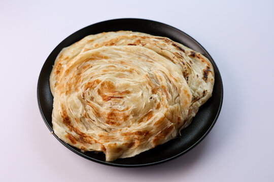 Kerala parathas porotta roti parotta barotta naan layered flatbread made from maida or whole wheat flour. Eat with spicy Asian chicken or beef or egg curry gravy. breakfast dish. Indian food.