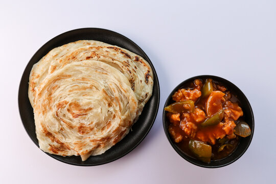 Kerala parathas porotta roti parotta barotta naan layered flatbread made from maida or whole wheat flour. Eat with spicy Asian chicken chili chicken beef curry gravy. breakfast dish. Indian food.