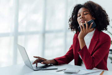 happy young businesswoman African American siting on the chiar cheerful demeanor raise holding coffee cup smiling looking laptop screen.Making opportunities female working successful in the office.
