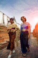 two asian woman wearing old thai tradition suit walking in ayutthaya temple one of world heritage site of unesco in thailand