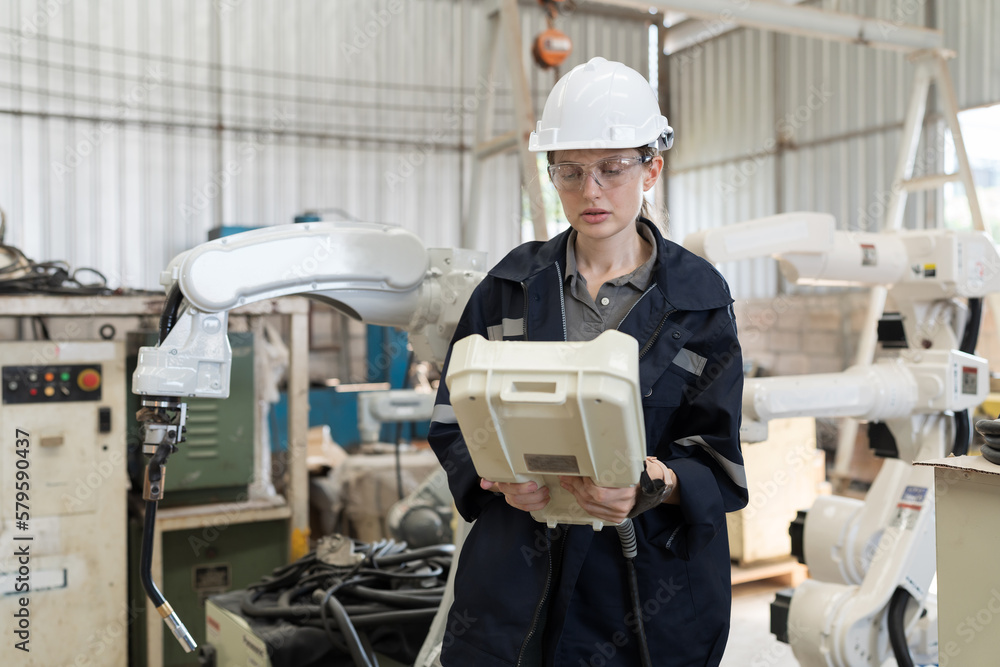 Fototapete female engineer control robot arm by remote robot control in workshop. woman technician working with