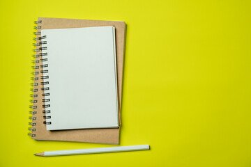 Top view Notebook with blank page on yellow background