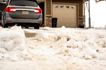 Snowbank at the end of a driveway left after city snowplows cleared a street.