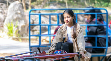 Asian girl on tractor walking with villagers on sunny day blurred and soft focus.