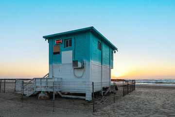 Lifeguard house on sea beach at sunset