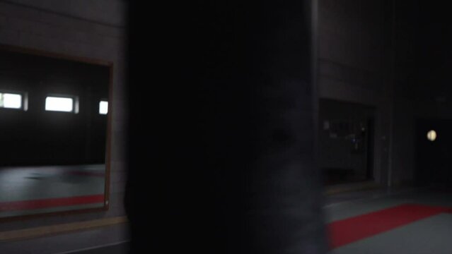 Aggressive kickboxer punching the heaby bag in an empty gym.