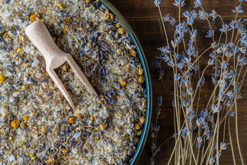 Fototapeta na wymiar Sea himalayan salt with dry lavender and chamomile flowers , closeup, top view