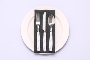 Plate with napkin and cutlery on white background