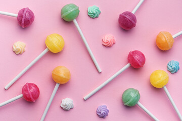 Sweet lollipops and candies on pink background