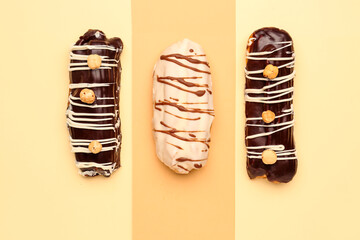 Tasty glazed eclairs on yellow and orange background