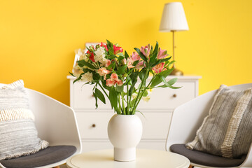 Interior of living room with armchairs and alstroemeria flowers on table