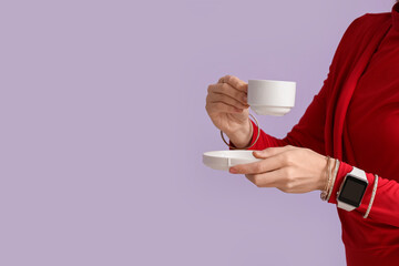 Woman with smartwatch and cup of coffee on lilac background, closeup