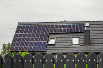 Obraz premium House roof with photovoltaic modules. Historic farm house with modern solar panels on roof and wall High quality photo