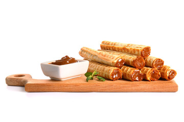 Board with delicious wafer rolls, boiled condensed milk and mint isolated on white background