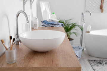 White sink on counter in light bathroom