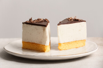 Plate with pieces of tasty birds milk cake on light background, closeup