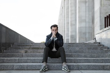 frustration of a middle-aged european man sitting on the steps of a building - obrazy, fototapety, plakaty