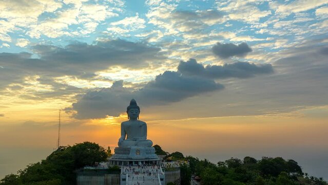aerial hyper lapse view Phuket big Buddha in beautiful sunset..the sun shines through the clouds impact on ocean surface.The beauty of the statue fits perfectly with the charming nature..cloud scape 