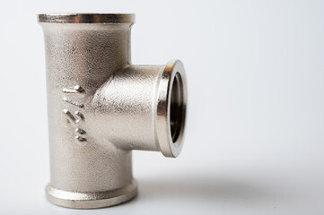 brass, metal tee connection for water isolated on light background close-up, connection for plumbing	
