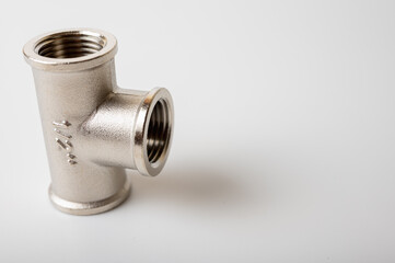 brass, metal tee connection for water isolated on light background close-up, connection for plumbing	
